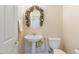 Powder room with pedestal sink, toilet and decorative mirror at 7611 Leybourne Ct, Las Vegas, NV 89131
