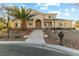 Two-story house with tan siding, landscaping, and a palm tree in the front yard at 7611 Leybourne Ct, Las Vegas, NV 89131