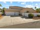 Three-car garage with a large driveway and a gate at 7611 Leybourne Ct, Las Vegas, NV 89131