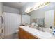 Bright bathroom featuring double sinks, a large mirror, and a shower with curtain at 9109 Lazy Hill Cir, Las Vegas, NV 89117