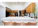 Well-lit kitchen featuring oak cabinets, white countertop, and a cozy breakfast bar at 9109 Lazy Hill Cir, Las Vegas, NV 89117