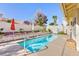Backyard pool with brick and lush landscaping, including an umbrella and seating at 9109 Lazy Hill Cir, Las Vegas, NV 89117