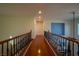 Upstairs hallway with hardwood floors and an open railing at 10500 Eagle Nest St, Las Vegas, NV 89141