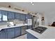 Modern kitchen with blue cabinets, stainless steel appliances, and a gas cooktop at 1320 Indian Hedge Dr, North Las Vegas, NV 89032