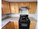 Kitchen with wood cabinets, granite counters, and black appliances at 1480 Hialeah Dr # B, Las Vegas, NV 89119