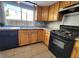 Kitchen with wood cabinets, granite counters, and black appliances at 1480 Hialeah Dr # B, Las Vegas, NV 89119