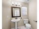 Clean bathroom with pedestal sink, toilet, and framed mirror at 1614 Redhawk Ct, Henderson, NV 89074