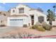 Two-story house with white exterior, a two-car garage, and landscaping at 1614 Redhawk Ct, Henderson, NV 89074