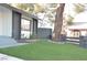 Artificial turf lawn with gray block wall and mature tree in front of the home at 1804 Piccolo Way, Las Vegas, NV 89146