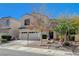 Two-story house with tan exterior, two car garage, and landscaping at 1805 Grand Rodeo St, Las Vegas, NV 89117