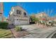 Two-story house with tan exterior, two car garage, and landscaping at 1805 Grand Rodeo St, Las Vegas, NV 89117