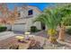 Two-story house with tan exterior, two car garage, and landscaping at 1805 Grand Rodeo St, Las Vegas, NV 89117