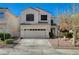 Two-story house with tan exterior, two car garage, and landscaping at 1805 Grand Rodeo St, Las Vegas, NV 89117