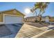 House exterior showcasing a tan house with a white garage door at 2210 Cool River Ct, North Las Vegas, NV 89032