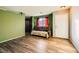 Living room with wood-look floors, a brown couch, and green walls at 2210 Cool River Ct, North Las Vegas, NV 89032