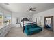 Main bedroom with a large bed, teal couch, and plenty of natural light at 2465 Sturrock Dr, Henderson, NV 89044