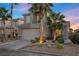 Two-story house with gray siding, palm trees, and a well-manicured front yard at 2465 Sturrock Dr, Henderson, NV 89044