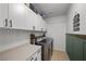 Laundry room with white cabinets, green wainscoting, and modern appliances at 2465 Sturrock Dr, Henderson, NV 89044