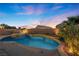 Inviting swimming pool and spa with a landscaped backyard at sunset at 2465 Sturrock Dr, Henderson, NV 89044