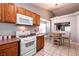 Kitchen with wood cabinets and white appliances, breakfast nook at 2535 River Oaks Dr, Las Vegas, NV 89156