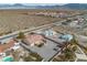 Aerial view showcasing a house, pool, and surrounding desert landscape with mountain views at 3361 Winery Rd, Pahrump, NV 89048