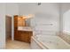 Bathroom features corner bathtub, wood cabinets and tiled floors at 3361 Winery Rd, Pahrump, NV 89048