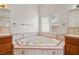 Relaxing bathroom with corner bathtub and wood cabinets at 3361 Winery Rd, Pahrump, NV 89048