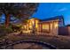 Well-lit home at dusk with stone accents and mature trees at 3361 Winery Rd, Pahrump, NV 89048