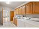 Laundry room with washer, dryer and oak cabinets at 3361 Winery Rd, Pahrump, NV 89048