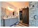 Renovated bathroom with dual vanity, tiled walls, and a glass enclosed shower with barn door to closet at 3402 Arcata Point Ave, Las Vegas, NV 89141