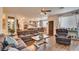 Inviting living room flows to kitchen, featuring hardwood floors, large sectional, and abundant natural light at 3402 Arcata Point Ave, Las Vegas, NV 89141