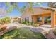 Landscaped backyard with covered patio and mature foliage at 36 Hunt Valley Trl, Henderson, NV 89052