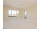 Bright bedroom featuring large window with nice view, neutral carpet, and ceiling fan at 36 Hunt Valley Trl, Henderson, NV 89052