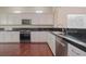 Modern kitchen featuring white cabinets, granite countertops, and stainless steel appliances at 36 Hunt Valley Trl, Henderson, NV 89052