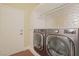 Modern laundry room featuring a stainless steel washer and dryer with built-in storage, combining convenience with style at 36 Hunt Valley Trl, Henderson, NV 89052