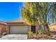 Beige house with a two-car garage and a large tree in the front yard at 4039 Welsh Pony St, Las Vegas, NV 89122