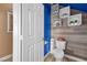 Bathroom features a modern toilet, wood-look accent wall, and decorative floating shelves at 41 Voltaire Ave, Henderson, NV 89002