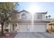 Bright exterior view of a two-story home with a three-car garage, desert landscaping, and tile roof at 41 Voltaire Ave, Henderson, NV 89002