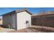 White storage shed with a door and exterior light fixture at 4641 Sommerset Ct, Pahrump, NV 89061