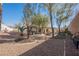 Landscaped backyard with gravel, trees, and a hot tub area at 493 Lace Haven Ct, Henderson, NV 89012