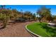 Manicured backyard featuring desert landscaping, artificial turf, and hillside views at 526 Highland View Ct, Mesquite, NV 89027