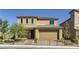 Two-story house with tan exterior, two-car garage, and landscaped front yard at 9280 Copernicus Ave, Las Vegas, NV 89143