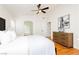 Bright and airy bedroom with ensuite bathroom view, ceiling fan, dresser, and natural light at 9741 Horizon Hills Dr, Las Vegas, NV 89117