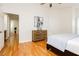 Bright bedroom featuring hardwood floors, a wooden dresser, and an abstract art piece above the dresser at 9741 Horizon Hills Dr, Las Vegas, NV 89117