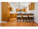 Inviting kitchen with wooden cabinets, white countertops, and three barstools at breakfast bar at 9741 Horizon Hills Dr, Las Vegas, NV 89117