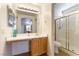 Bathroom with wood vanity, large mirror and shower at 10957 Civiletti St, Las Vegas, NV 89141