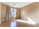 Well-lit bedroom, featuring wood floors and window with curtains at 10957 Civiletti St, Las Vegas, NV 89141