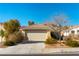 Tan one-story house with a two-car garage and desert landscaping at 10957 Civiletti St, Las Vegas, NV 89141
