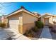Front view of a beige house with a two-car garage and walkway at 10957 Civiletti St, Las Vegas, NV 89141