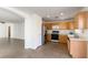 Oak kitchen cabinets, tile flooring, and a view into living room at 10957 Civiletti St, Las Vegas, NV 89141